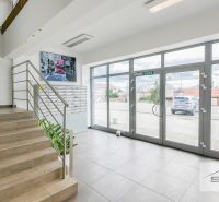 An office interior with a staircase, mailboxes, and large glass doors.