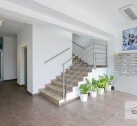 A staircase with stainless steel railing and mailboxes in the office.