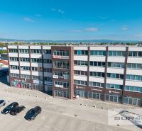 Offices on Svornosti in Bratislava - Podunajské Biskupice with a parking lot and cars.