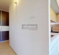 A hallway with ceramic tiles, a built-in wardrobe, and a kitchen with wooden decor in a 3-room apartment.