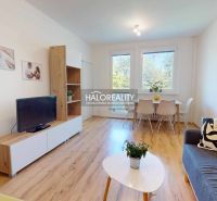 Living room in a 3-room apartment with a wooden decor floor, a television, and a dining table.
