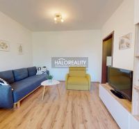 Living room with a corner sofa in a 3-room apartment, wooden decor flooring, modern interior.