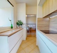 A kitchen in a 3-room apartment with tiles and a wooden decor floor.