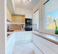 Kitchen in a 3-room apartment with white cabinets and wood decor.
