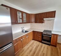 A kitchen with built-in appliances and a wooden decor floor in a 2-room apartment.