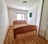 A bedroom with a wooden bed and a built-in wardrobe in a 2-room apartment.