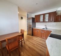 A kitchen with wooden furniture and appliances in a 2-room apartment.