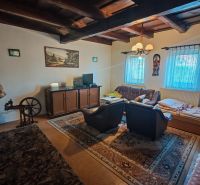 Living room with a carpet, wooden ceiling, and television in a family house.