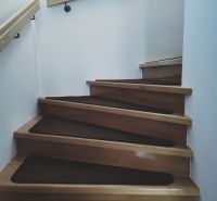 Interior with wooden stairs and railing in a family house.