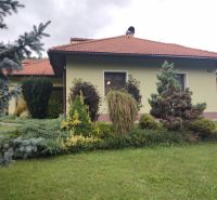 A family house in Trebostovo, with a landscaped garden featuring plants and trees in the front.