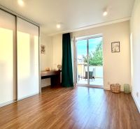 Interior of a 3-room apartment with a wooden decor floor and a spacious terrace.