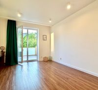 A bright room with access to a balcony, wooden decor flooring in a 3-room apartment.