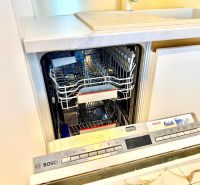 Dishwasher in the kitchen of a 3-room apartment, open door showing the interior.