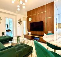 A living room in a 3-room apartment with a marble floor and green sofas.