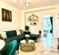 Interior of a 3-room apartment with a sofa, glass table, and artistic decorations on the wall.