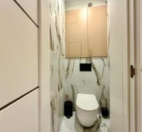 Bathroom in a 3-room apartment with marble-patterned tiles and a wall-mounted toilet.