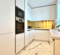White kitchen in a 3-room apartment with marble flooring and built-in appliances.