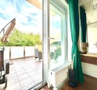 Interior of a 3-room apartment with a terrace, wooden decor flooring, green curtains.