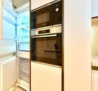 A kitchen unit with a refrigerator and built-in appliances in a 3-room apartment.