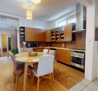 A kitchen in a family house with a wooden decor floor and a dining table.
