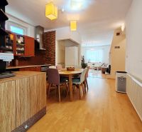 A kitchen in a family house with a wooden decor floor, a table, and appliances.