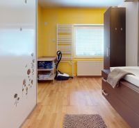A bathroom in a family house with a wooden decor floor, yellow tiles, and a sink.