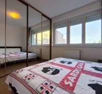 Bedroom with a large mirrored wardrobe in a 2-room apartment, floor with wood decor.