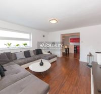 Interior of a family house with a wooden decor floor, large sofa, and modern seating.