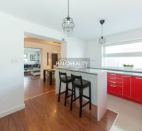 A kitchen in a family house with red kitchen cabinets and a wooden decor floor.