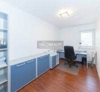A study with an office desk, chair, and shelf in a family house, with a wooden-patterned floor.