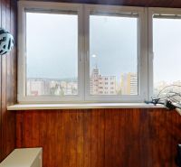 Glazed loggia with wooden paneling and a bicycle in a 3-room apartment.