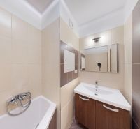 Bathroom in a 3-room apartment with a shower, sink, and tiles in brown shades.