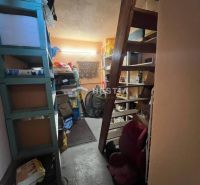 Storage space with shelves and staircase in a family house.
