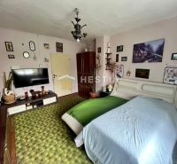 A bedroom in a family house with a carpet and decorations on the wall.