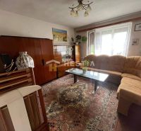 Living room in a family house with a carpet and a glass cabinet.