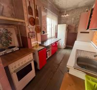 A kitchen in a family house with a wooden decor floor and retro furniture.