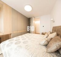Bedroom in a 3-room apartment with storage spaces and a bed with patterned textiles.