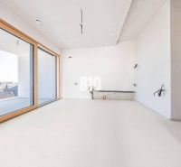 A room with large windows and a wooden decor floor in a 3-room apartment.