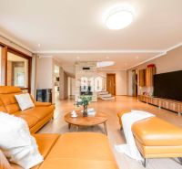 Living room with wood-patterned flooring, orange sofa, and fireplace in a family house.