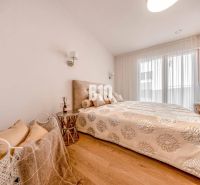 A bedroom in a 3-room apartment with a bed and a floor with a wooden decor.