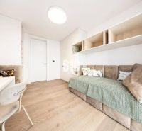 A minimalist room with a sofa, light furniture, and a wooden decor floor in a three-room apartment.