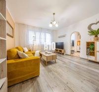 Living room in a two-room apartment with a yellow sofa and a wooden decor floor.