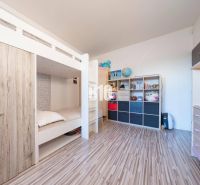 Children's room with a bunk bed, storage space, and a floor with a wooden decor.