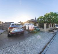 The courtyard of a family house in Most pri Bratislave with parking spaces and parked cars.