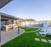 A family house in Most pri Bratislave with a terrace, a swimming pool, and sun loungers on the lawn.