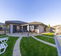 A family house in Most pri Bratislave with a terrace, a swimming pool, and sun loungers in the garden.