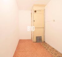 A narrow room in a 4-room apartment with a wooden decor floor and a cabinet.