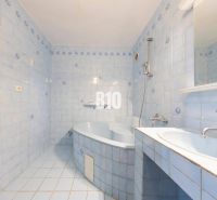 A bathroom with light blue tiles, a bathtub, and a sink in a 4-room apartment.