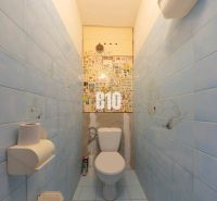 A bathroom in a 4-room apartment with blue tiles and a toilet.