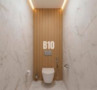 A bathroom in a 4-room apartment with marble tiles and wooden decor on the wall.